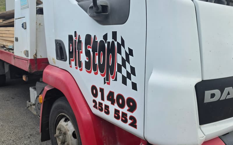 The Pit Stop recovery truck, a white DAF flatbed with the Pit Stop chequered flag logo and 01409 255552 on the cab door